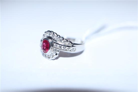 A modern stylish 18ct white gold, ruby and diamond oval cluster ring, with diamond set shoulders, size L/M.